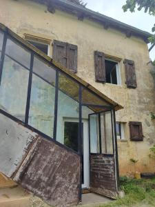 an old building with a door and windows at Maisonnette de vignes avec vue imprenable in Marvejols