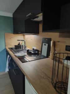 a kitchen with black cabinets and a counter top at Maisonnette de vignes avec vue imprenable in Marvejols