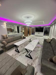 a living room with a couch and a table at Villa Imperium Indoor & Outdoor Pool Riverfront Bjelašnica View in SJJ