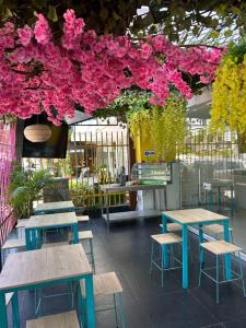a room with tables and chairs and pink flowers at Hotel Sun Suite in Barranquilla