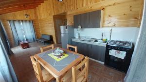 a small kitchen with a table and a stove at Cabañas Aguapiedras in Linares