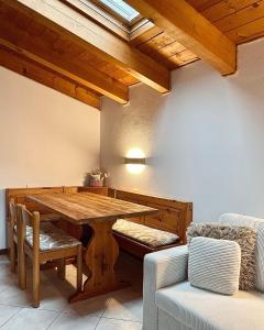 a dining room with a wooden table and a couch at Mansarda Spadone in Musso