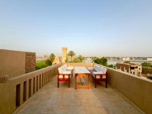 a patio with a table and chairs on a balcony at Djorff Palace - Private villa & swimming pool & central location in Al Aqālitah