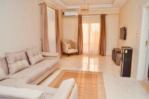 a living room with a couch and a tv at Djorff Palace - Private villa & swimming pool & central location in Al Aqālitah
