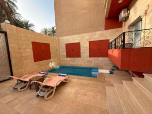 a swimming pool in the middle of a house at Djorff Palace - Private villa & swimming pool & central location in Al Aqālitah