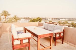 a patio with a table and chairs on a balcony at Djorff Palace - Private villa & swimming pool & central location in Al Aqālitah