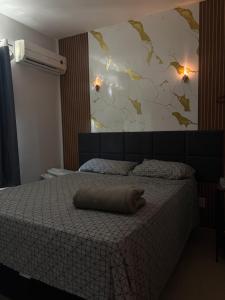 a bedroom with a bed with a pillow on it at Apartamento Com Piscina prox a BR in Ananindeua