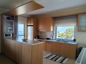 a kitchen with wooden cabinets and a large window at The View in Souvala