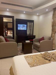 a living room with a bed and a tv at رولانا للشقق المخدومة Rolana Serviced Apartments in Jeddah