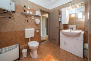 a bathroom with a toilet and a sink at Varga Vendégház in Tótszerdahely +62 photos