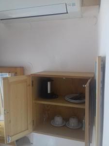 a cupboard in a kitchen with a microwave at Pension Castello in Rethymno