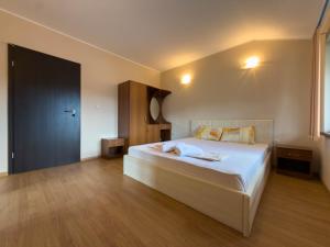 a bedroom with a large bed with white sheets at Къща за гости Sunrise - Батак in Batak