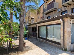 a building with a large window next to a palm tree at Il Giardino del Belvedere in Barrafranca
