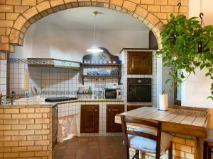 an archway in a kitchen with a table and a stove at Il Giardino del Belvedere in Barrafranca +14 photos