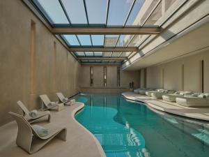 a swimming pool with lounge chairs and a large glass ceiling at Minos Palace Resort - Adults Only in Agios Nikolaos +125 photos