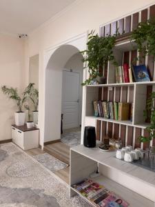 a living room with a book shelf with books at Tabylga guest house in Jalal-Abad