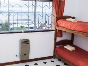 a room with bunk beds and a window with a view at Hostel Inn Bariloche in San Carlos de Bariloche