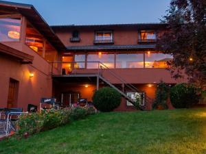 a house with a lawn in front of it at Hostel Inn Bariloche in San Carlos de Bariloche