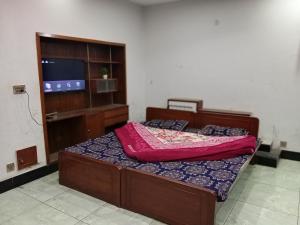 a bedroom with a bed and a flat screen tv at Nice Guest House GPO Murree in Murree