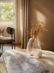 a vase with flowers in it sitting on a table at Stylish City Center Escape- Where Modern Elegance Meets History in Trier