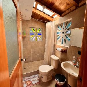 a bathroom with a toilet and a sink at Hostal Doña Clarita Inn in Chugchilán
