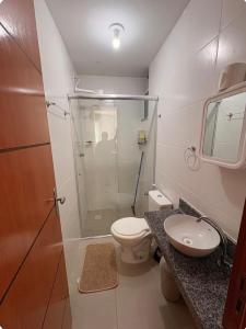 a bathroom with a shower and a toilet and a sink at Apartamento Com Piscina prox a BR in Ananindeua +4 photos