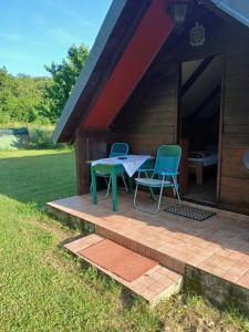 a patio with two chairs and a table in front of a cabin at Hidden Nest For Two in Herceg-Novi