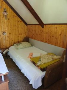 a large bed in a room with wood paneling at Hidden Nest For Two in Herceg-Novi