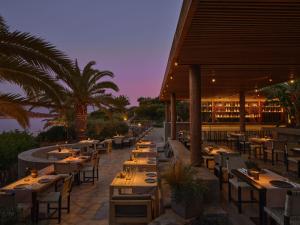 a restaurant with wooden tables and chairs at Minos Palace Resort - Adults Only in Agios Nikolaos