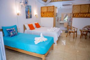 two beds in a room with two chairs and a table at La Villa Allamanda in Rodrigues Island +69 photos