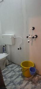 a bathroom with a bucket in the corner with a toilet at The Green resort goa in Canacona