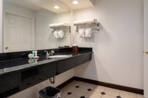 a bathroom with a sink and a mirror at Capital City Inn Sacramento Convention Center CA in Sacramento +12 photos