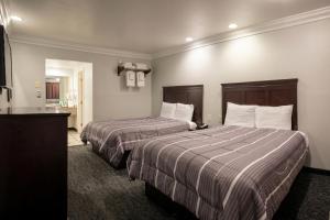 a hotel room with two beds and a bathroom at Capital City Inn Sacramento Convention Center CA in Sacramento