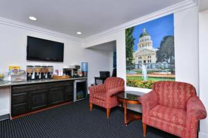 a room with two chairs and a table and a tv at Capital City Inn Sacramento Convention Center CA in Sacramento