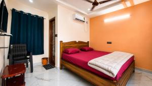 a bedroom with a wooden bed with red sheets at Sai krishna residency in Pithāpuram