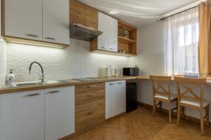 a kitchen with white cabinets and a sink at Beata Marek Pod Grapą in Białka Tatrzańska