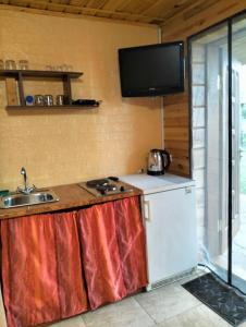 a kitchen with a refrigerator and a tv on the wall at Krainya hata in Melʼniki