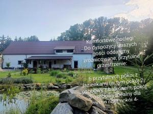 a house with a sign in front of it at Noclegi i sauna w starym domu in Pławnica