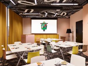 a conference room with tables and a projection screen at Mama Shelter Roma in Rome