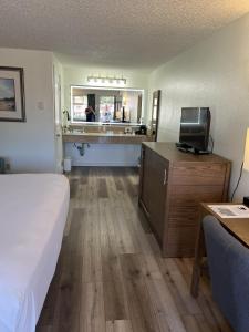 a hotel room with a bed and a kitchen at Super 8 by Wyndham Florence OR in Florence