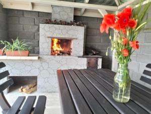 a vase of flowers on a table with a fireplace at Krainya hata in Melʼniki