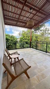 a patio with two chairs and a table and a basket at Villa Rosa Dreams 2 in Ungasan