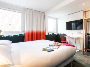 a bedroom with a bed with a chair and a television at ibis Styles Thonon-les-Bains in Thonon-les-Bains +76 photos