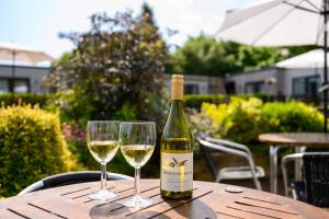 two glasses of white wine sitting on a table at Shenstone Lodge in Kidderminster