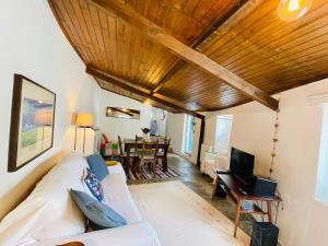 a living room with a white couch and a wooden ceiling at Refúgio da Alma in Mafra