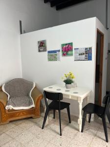 a room with a table and chairs and a table with flowers at Casa Vega-Marrero in Arucas