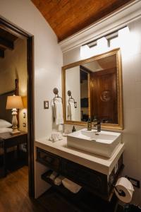 ein Badezimmer mit Waschbecken und Spiegel in der Unterkunft Los Pasos Boutique Hotel & Spa in Antigua Guatemala + 109 Fotos