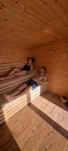 two naked people laying in a wooden sauna at Domki La Plata in Łeba
