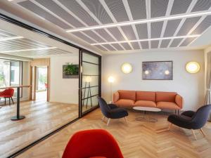 a living room with a couch and chairs at Novotel Cambridge North in Cambridge