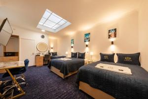 a hotel room with two beds and a desk at Jubilee Hotel Victoria in London +246 photos